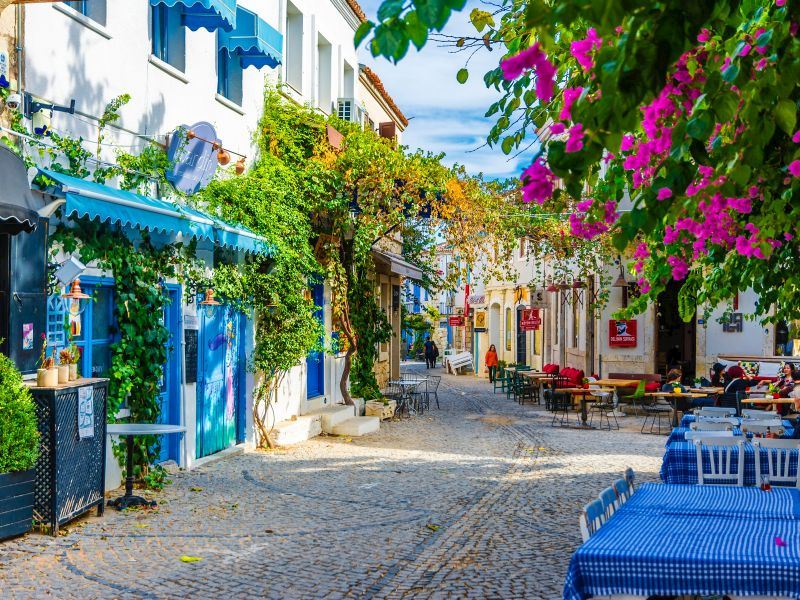 Stone street with bougainvillea flowers in Alaçatı, Izmir, Turkey